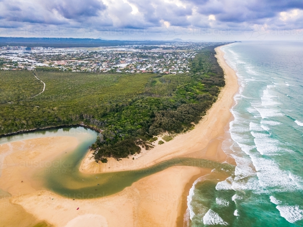 Aerial view of a river winding through a beach and out to sea - Australian Stock Image