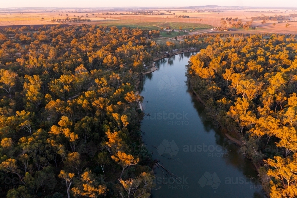 Aerial view of a river winding through a forest in late afternoon lighting - Australian Stock Image