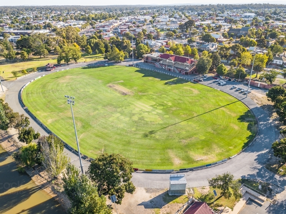 Aerial view of a road surrounding a football oval and grandstand - Australian Stock Image