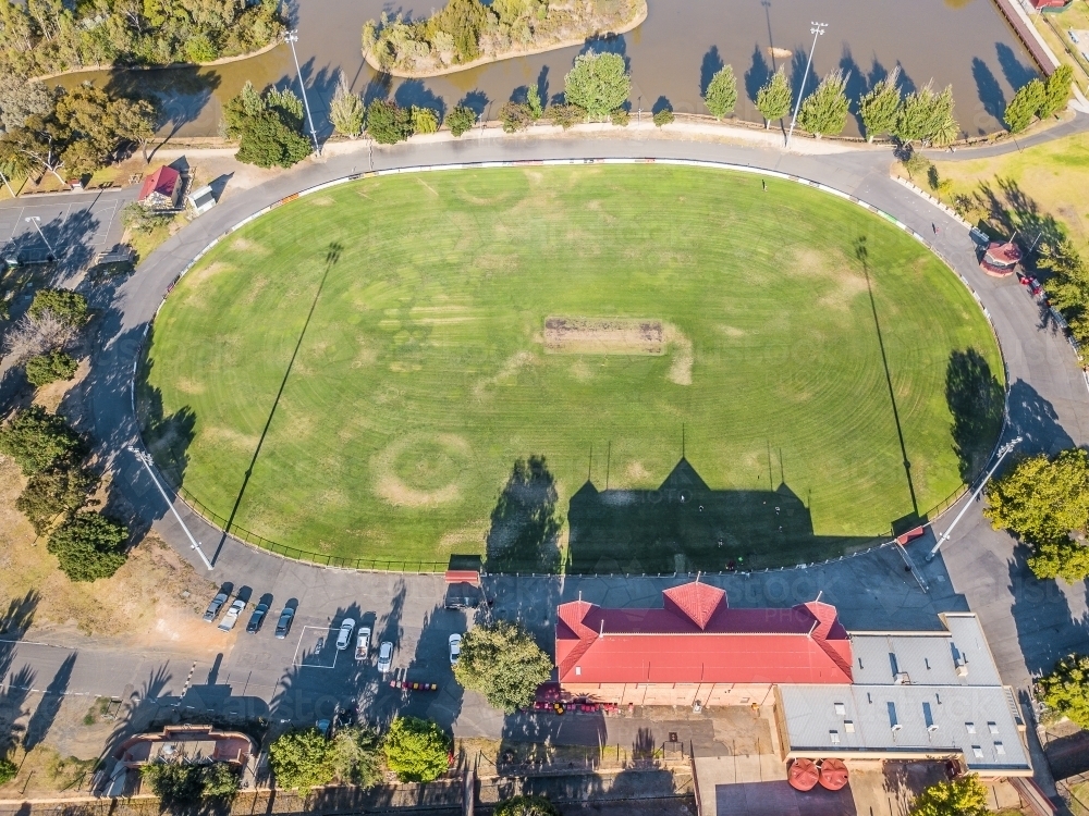 Aerial view of a road surrounding a football oval and grandstand - Australian Stock Image