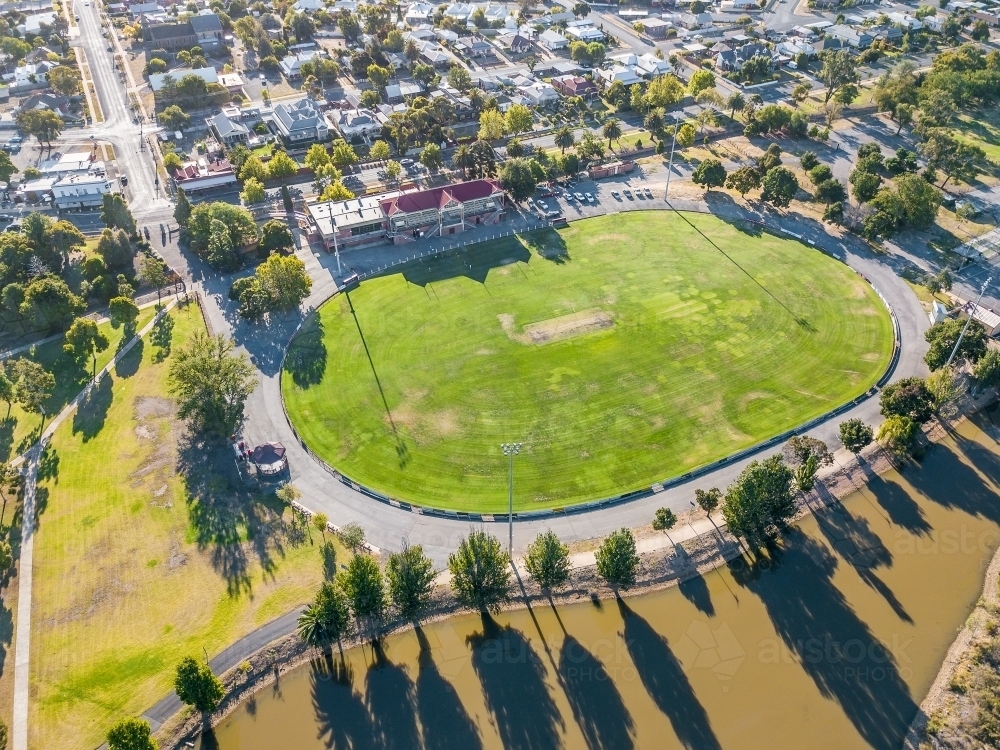 Aerial view of a road surrounding a football oval and grandstand - Australian Stock Image