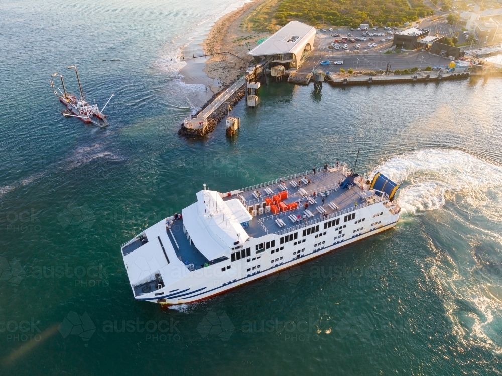 Aerial view of a sea ferry at a transport terminal near a coastal marina - Australian Stock Image