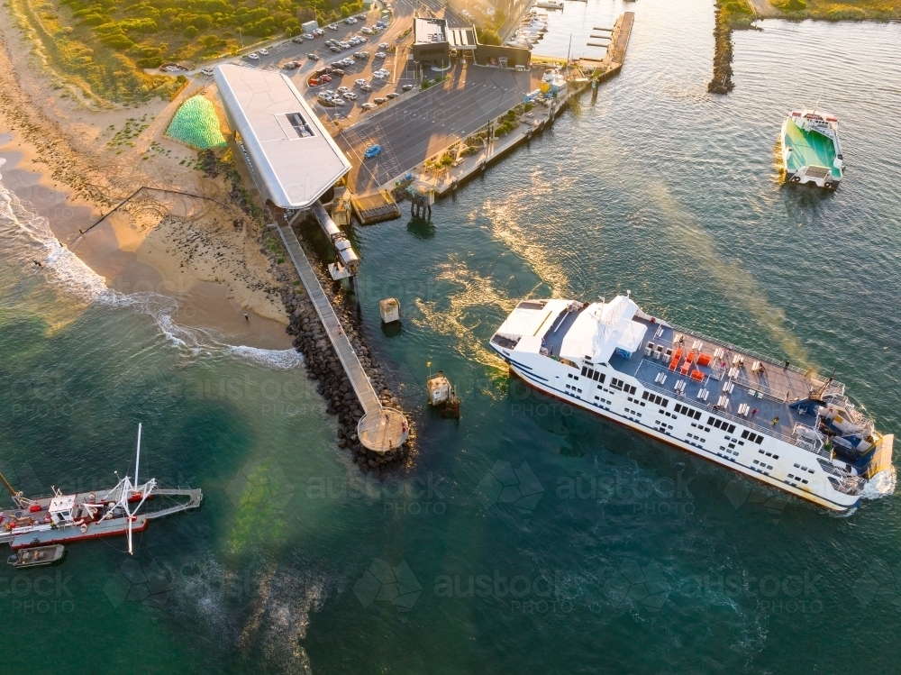 Aerial view of a sea ferry at a transport terminal near a coastal marina - Australian Stock Image