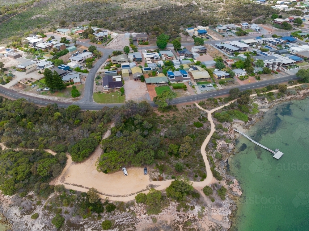 Aerial view of a small coastal town with gravel carpark and walking tracks - Australian Stock Image