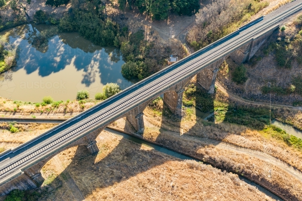 Aerial view of a stone viaduct over a river and water channel - Australian Stock Image