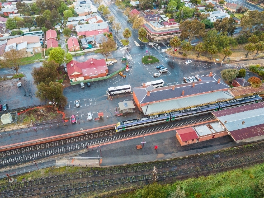 Aerial view of a train and buses at a country railway station - Australian Stock Image