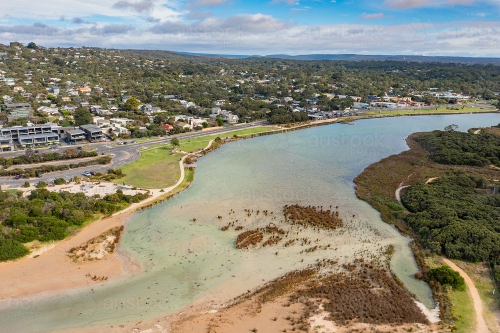 Aerial view of a wide river flowing through a coastal town - Australian Stock Image