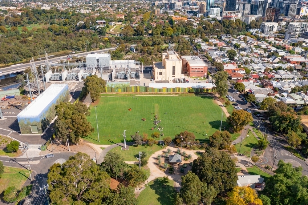 Aerial view of an inner city sports field with an electrical power station nearby - Australian Stock Image