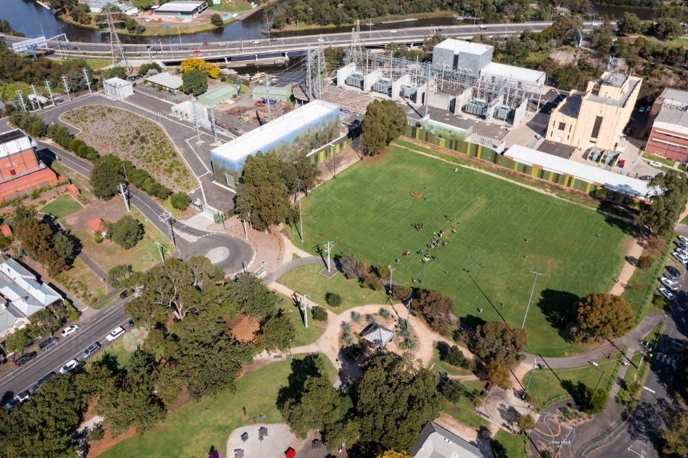 Aerial view of an inner city sports field with an electrical sub-station and freeway overpass - Australian Stock Image