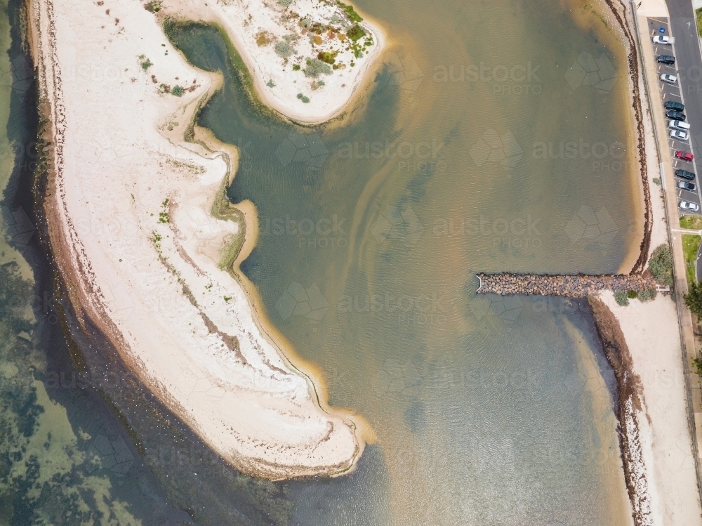 Aerial view of an unusually shaped coastal sand bar opposite a coastal carpark and breakwater - Australian Stock Image