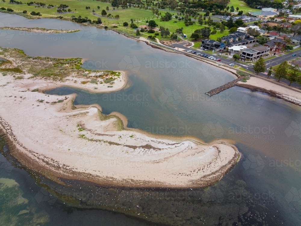 Aerial view of an unusually shaped sand bar running along the coast opposite parkland - Australian Stock Image