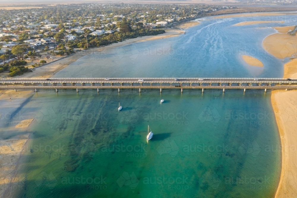 Aerial view of bridges across a river mouth around a coastal town - Australian Stock Image