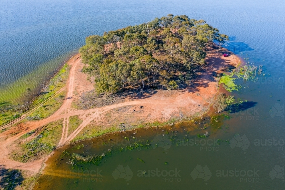 Aerial view of car track leading onto an island covered in gum trees - Australian Stock Image