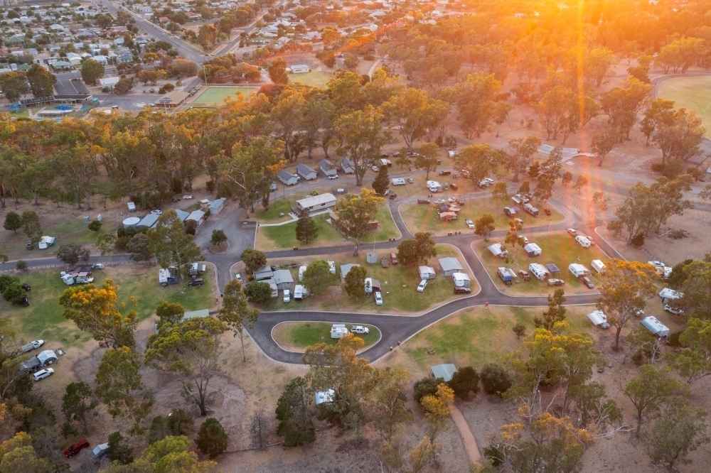 Aerial view of caravan park in a bush setting at sunrise - Australian Stock Image