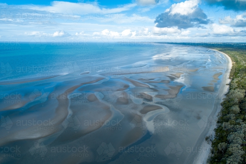 Aerial view of coastline and sandbar patterns in shallow blue water. - Australian Stock Image