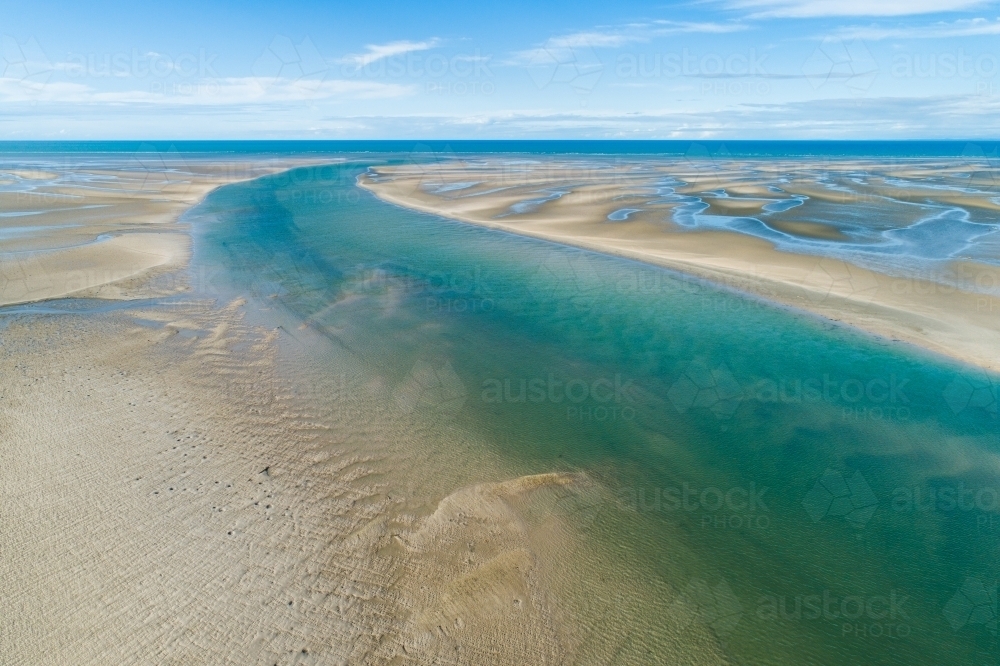 Aerial view of creek and sandbar patterns in shallow blue water. - Australian Stock Image