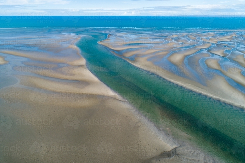 Aerial view of creek and sandbar patterns in shallow blue water. - Australian Stock Image