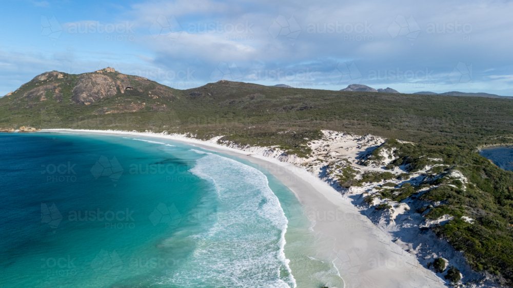 Aerial view of crescent-shaped beach with turquoise water. - Australian Stock Image