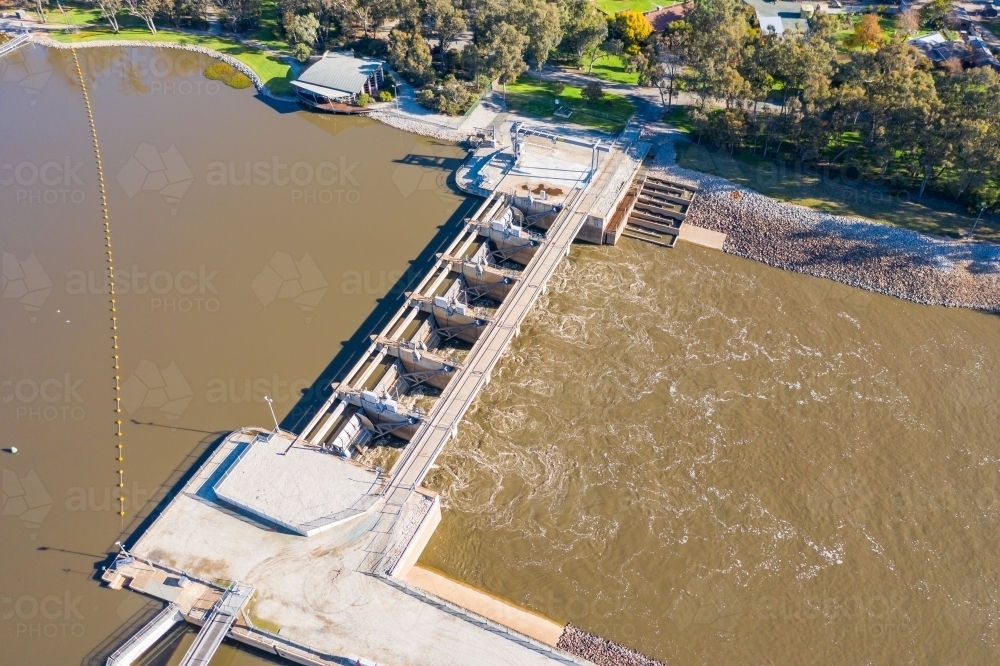 Image of Aerial view of dirty river water rushing through the gates of ...