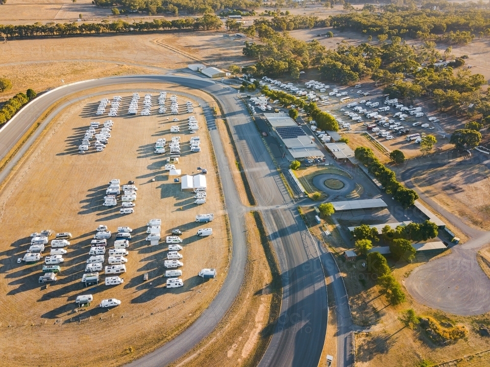 Aerial view of dozens of motorhomes parked at a racetrack - Australian Stock Image