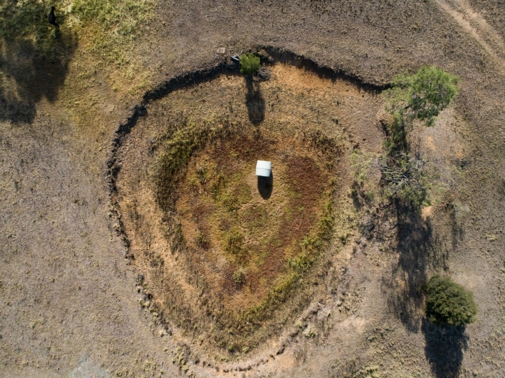 Aerial view of empty dam in dry paddock - Australian Stock Image