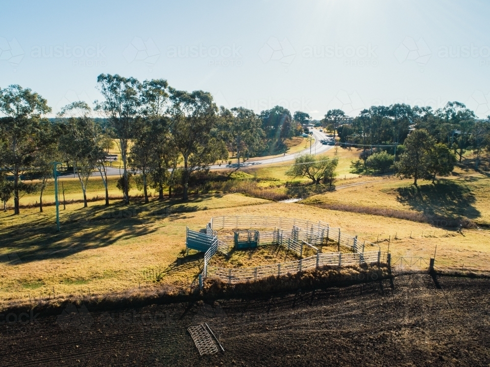 Aerial view of farm land with ploughed paddock and cattle yards - Australian Stock Image