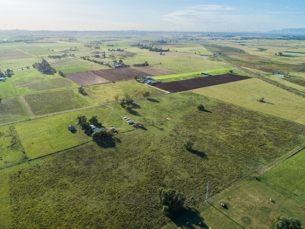 aerial view of farm paddocks at the edge of town with train line - Australian Stock Image