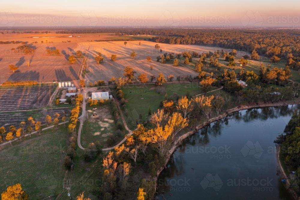 Aerial view of farmland alongside a river in early morning sunshine - Australian Stock Image