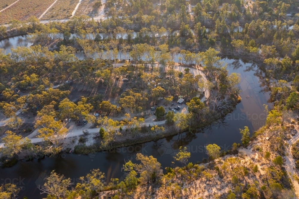 Aerial view of hairpin bends in a murky river lined with gumtrees - Australian Stock Image