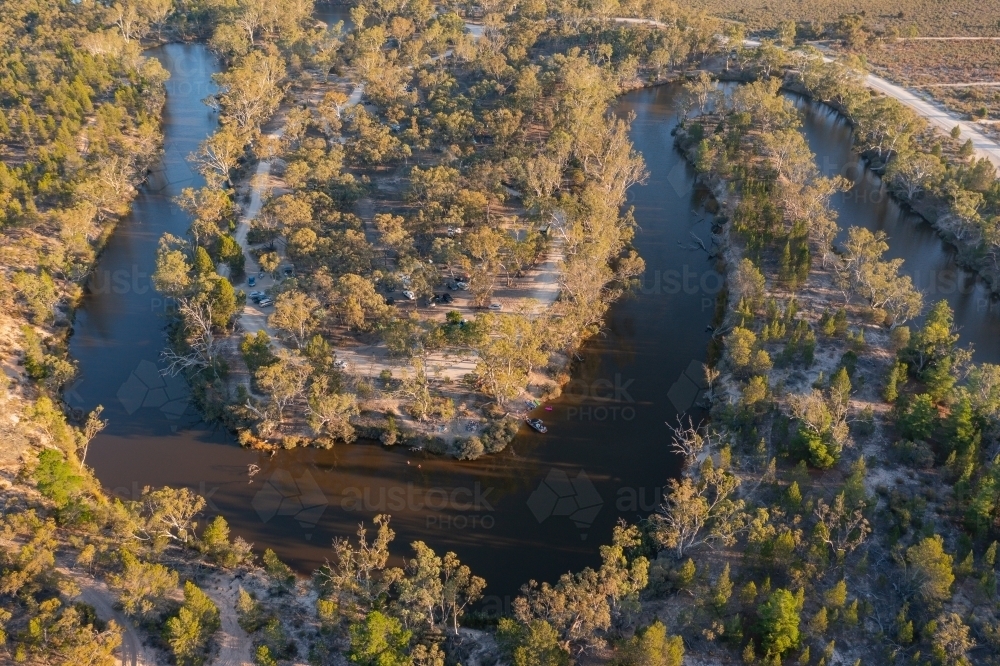 Aerial view of hairpin bends in a murky river lined with gumtrees - Australian Stock Image