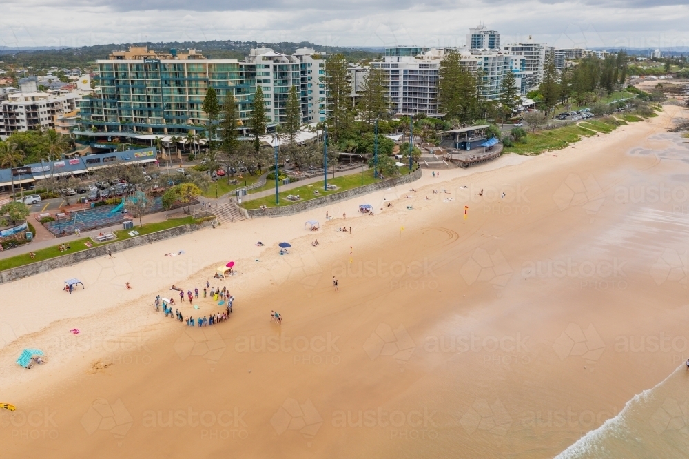 Aerial view of high rise real estate along a waterfront with people along the beach - Australian Stock Image