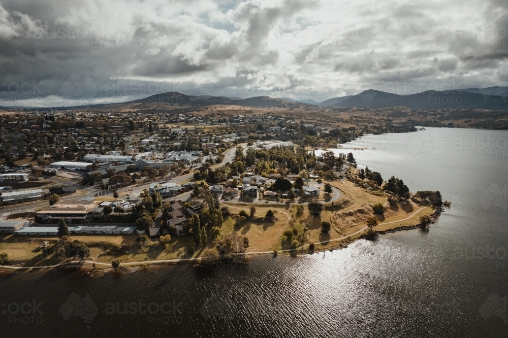 Aerial view of Jindabyne main town centre with the Snowy Mountains in the background - Australian Stock Image