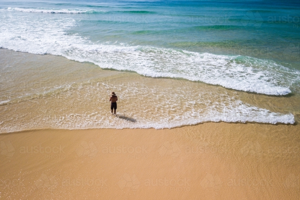 Image of aerial view of man fishing in ocean - Austockphoto