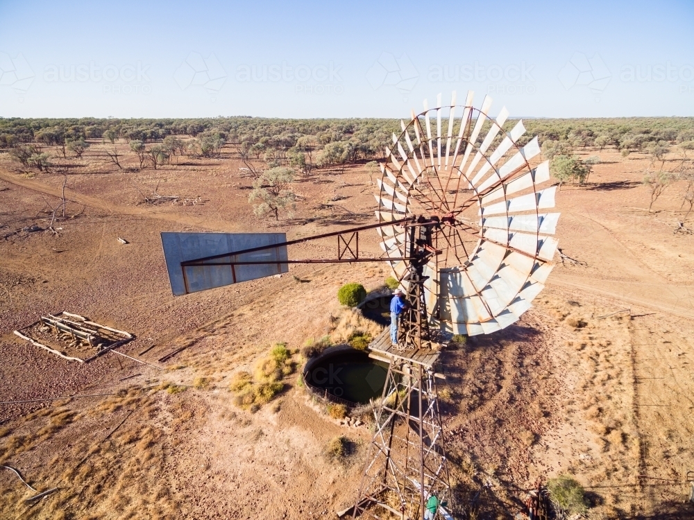 Aerial view of man repairing windmill - Australian Stock Image