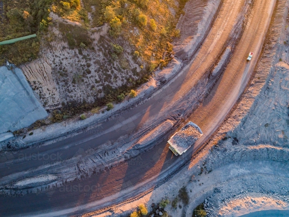 Aerial view of mining dump truck full of rocks hauling overburden through open cut coal mine site - Australian Stock Image