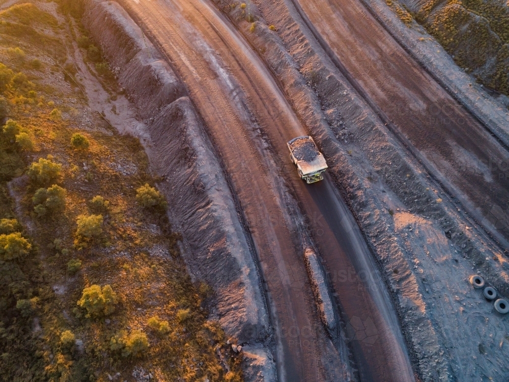 Aerial view of mining dump truck full of rocks hauling overburden through open cut coal mine site - Australian Stock Image