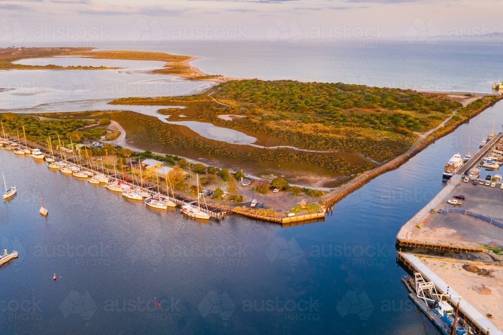 Aerial view of narrow channel joining a yacht harbour and a coastal bay. - Australian Stock Image