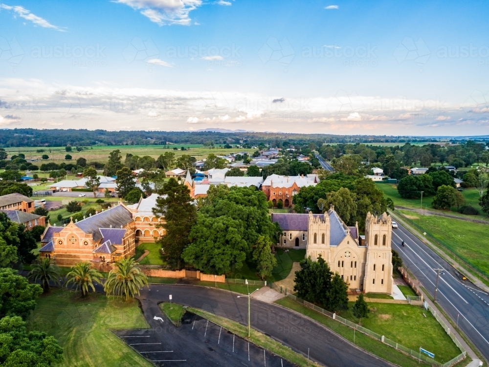 Aerial view of old church building made of stone lit with glow of faint evening sunlight - Australian Stock Image