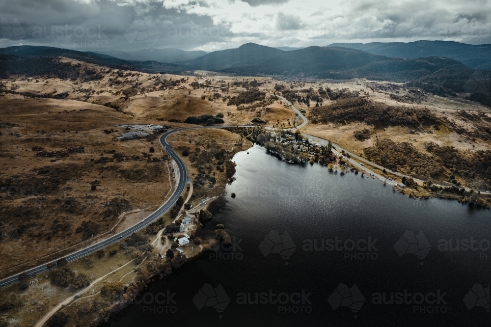 Aerial view of outskirts of Jindabyne with the 'Alpine Way' leading into the Snowy Mountains - Australian Stock Image