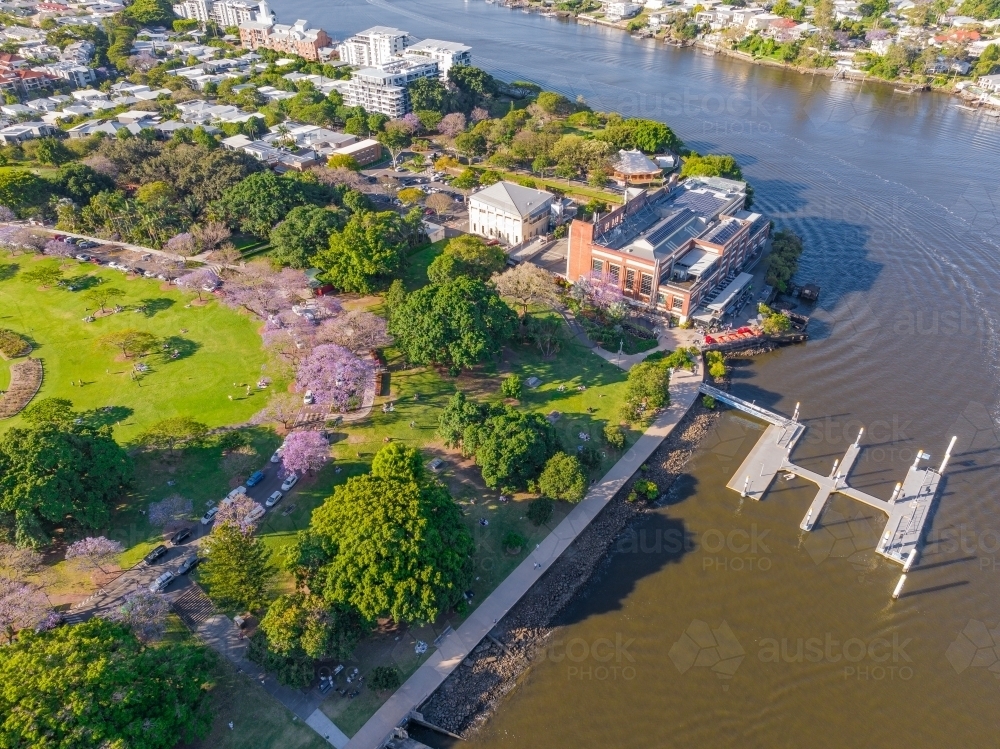 Aerial view of parkland and museum and jetty alongside a river running through a city - Australian Stock Image