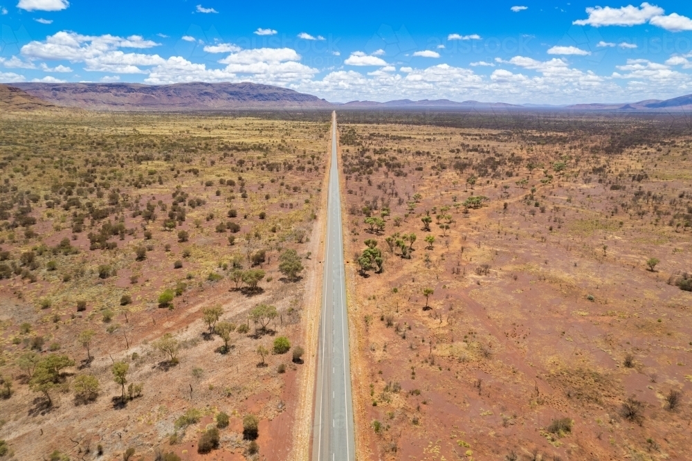 Aerial view of remote asphalt road surrounded by dry arid land - Australian Stock Image
