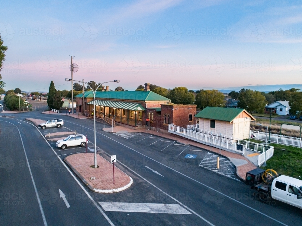 Aerial view of road and train station showing public transport infrastructure at dusk - Australian Stock Image