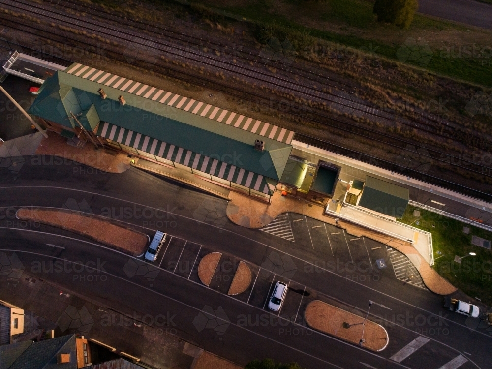 Aerial view of road and train station showing public transport infrastructure at dusk - Australian Stock Image