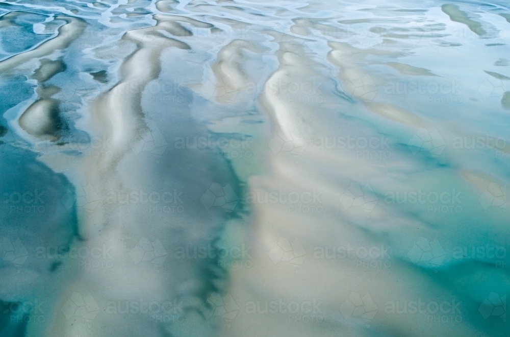 Aerial view of sandbar patterns in shallow blue water. - Australian Stock Image