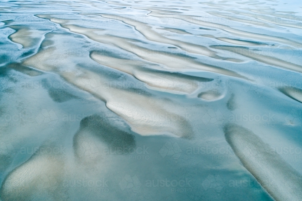 Aerial view of sandbar patterns in shallow blue water. - Australian Stock Image