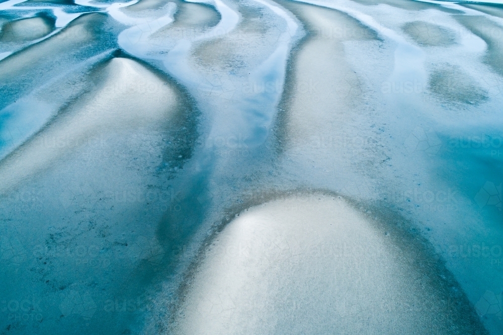 Aerial view of sandbar patterns in shallow blue water. - Australian Stock Image