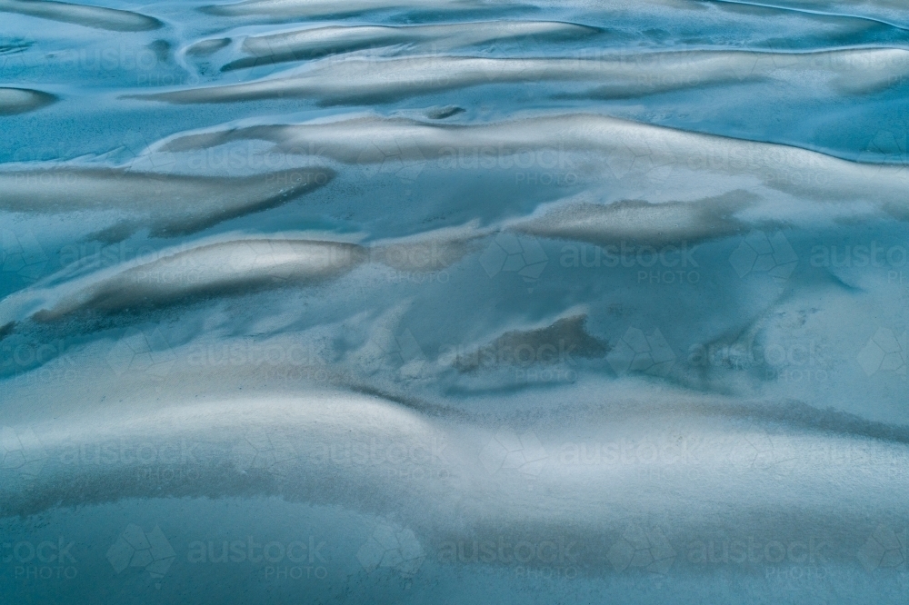 Aerial view of sandbar patterns in shallow blue water. - Australian Stock Image