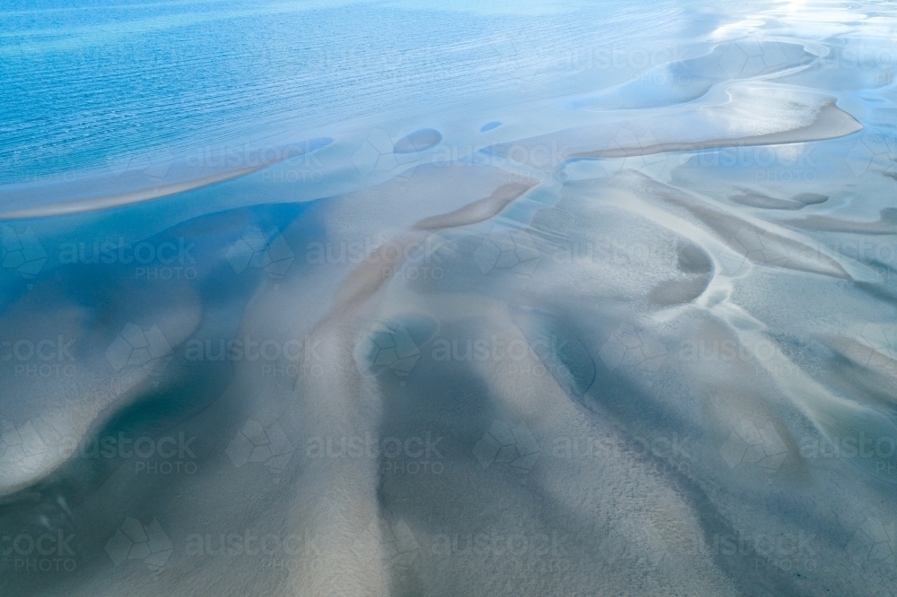 Aerial view of sandbar patterns in shallow blue water. - Australian Stock Image