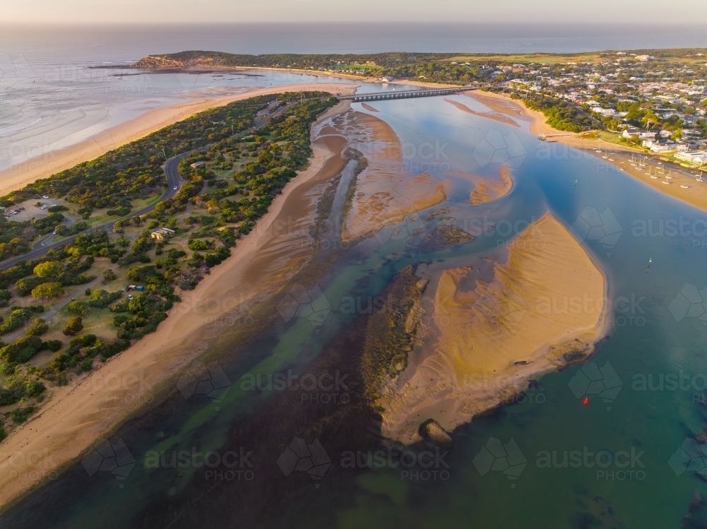 Aerial view of sandbars in a coastal river flowing out to sea - Australian Stock Image