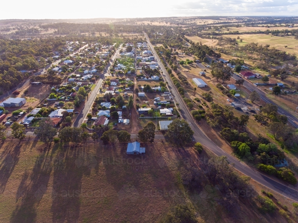 aerial view of small rural town looking towards horizon with long shadows - Australian Stock Image